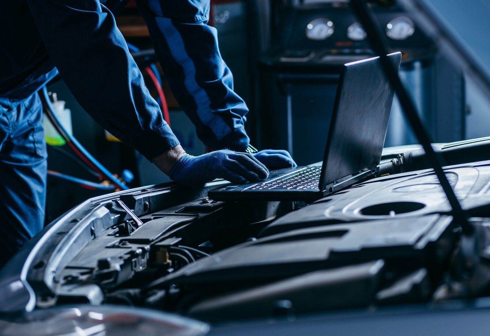 Ein Mann prüft ein Auto mit einem Laptop